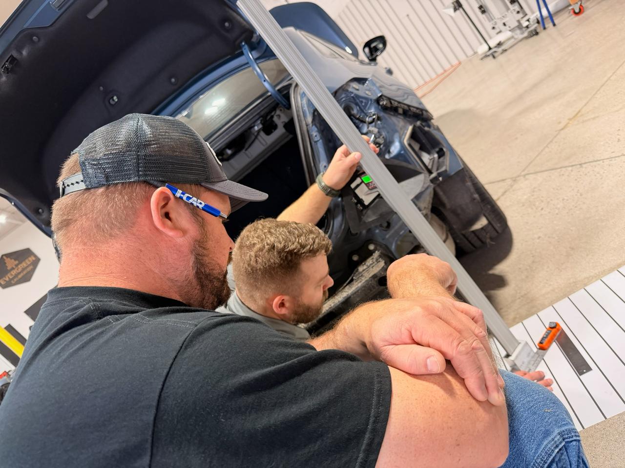Technician using the ADAS Blind Spot Aiming Tool Kit digital angle guide on a vehicle after collision repair